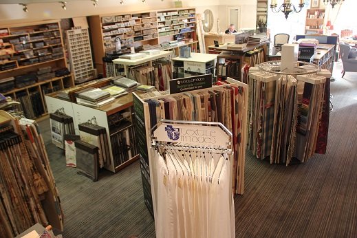 Stacks of fabric and wallpaper sample books along the showroom wall