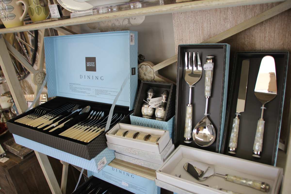 A giftware display of cutlery and serving pieces laid out on a showroom table