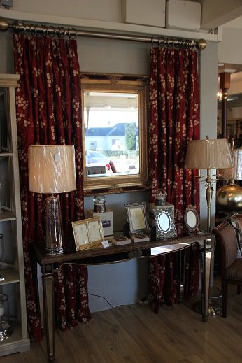 A red patterned curtain hung full length beside a showroom window