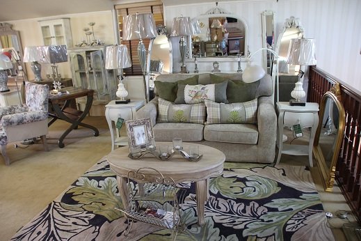 Two sofas facing each other across a rug in the showroom, table lamps lit on either side