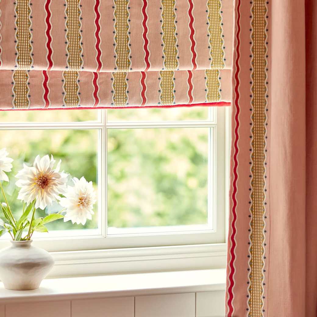 A striped Roman blind over a kitchen window above a worktop